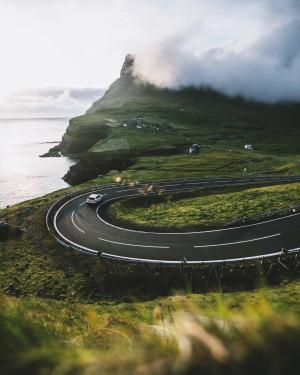 Car driving on picturesque curvy roads of the Faroe Islands