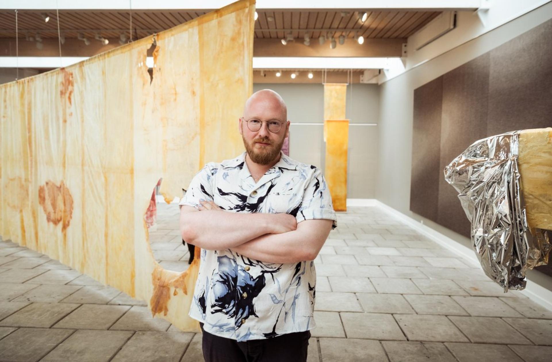 Jón Sonni Jensen with his artworks displayed at the National Gallery in the Faroe Islands. 
