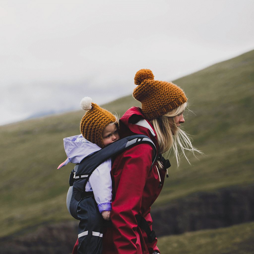 Woman walking in the mountains with a baby on her back