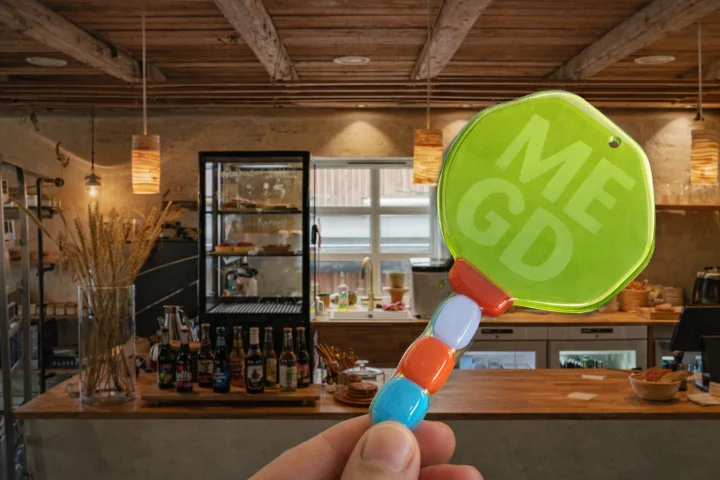 MEGD key in front of a café Fiskastykkið, symbolising accessible restaurants and venues.