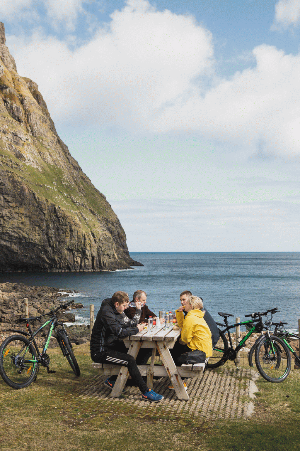 People on a bike trip in Suðuroy, Faroe Islands. Enjoying a nice lunch with a view of the sea. Taken by Kirstin Vang 